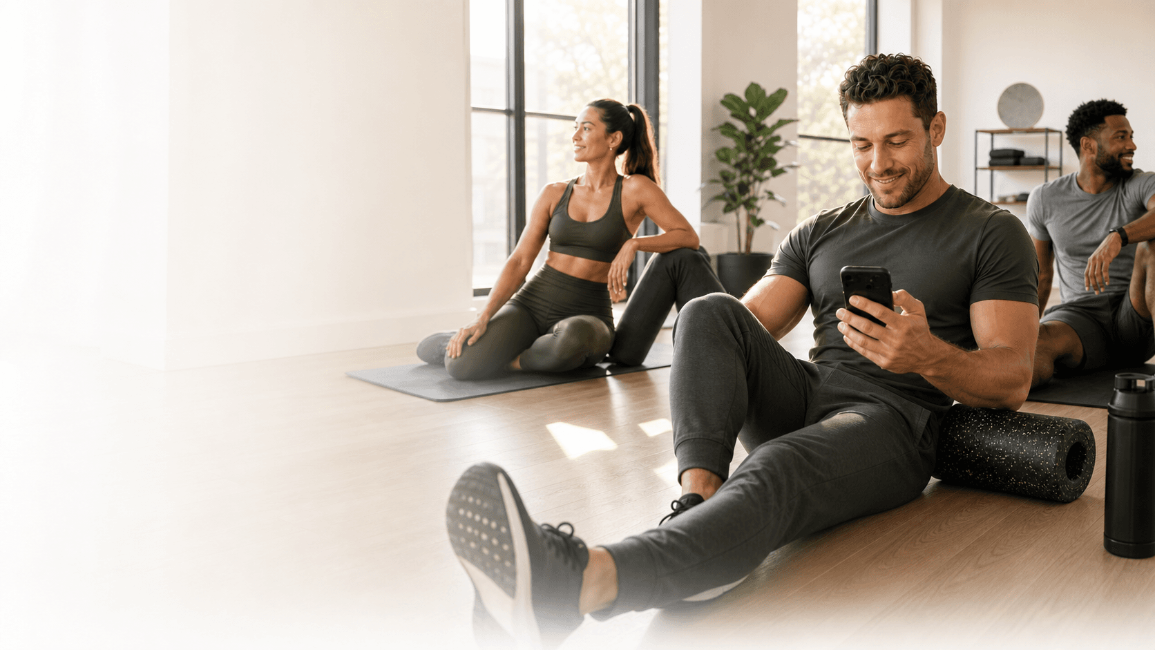 Fit adults in a bright wellness studio reviewing their routine after training